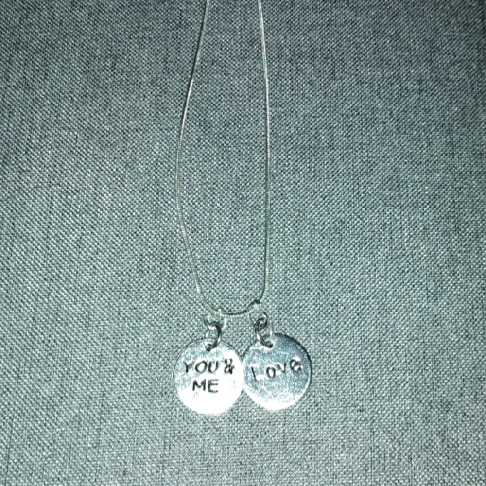 Pretty silver necklace with 2 charms attached.